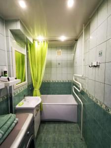 a bathroom with a tub and a sink and a bath tubermottermott at Aukštaičių apartamentai in Rokiškis