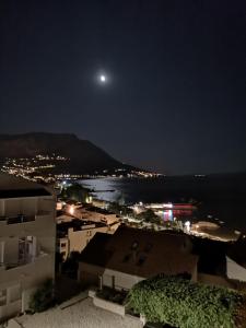 a view of a city at night with the moon at Apartmani "Grgic" in Omiš