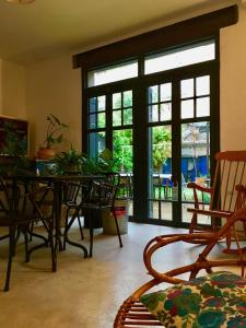 a dining room with a table and chairs and windows at Les Cagettes en Ville in Perpignan