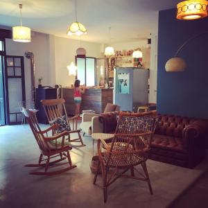 a living room with chairs and a couch and a kitchen at Les Cagettes en Ville in Perpignan