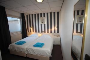 a bedroom with a bed with two blue towels on it at Het Wapen van Enkhuizen in Enkhuizen