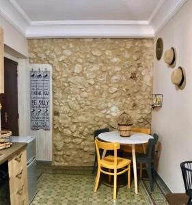 a table and chairs in a kitchen with a stone wall at “La Rampa” Affitti Brevi - Racalmuto (AG) Sicilia in Racalmuto