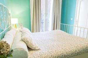 a bedroom with a bed with a floral bedspread and a window at Hostal Five Gates in Osuna