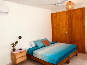 1 dormitorio con 1 cama y puerta de madera en Casa Alberto Cozumel en Cozumel