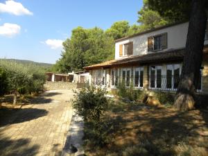 a house with a dog laying in front of it at Les Vallons Holiday Home in Lioux