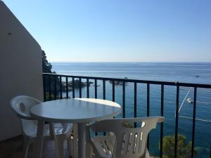 a table and chairs on a balcony overlooking the ocean at STUDIOS FACE À LA MER - Cala Llevado in Tossa de Mar