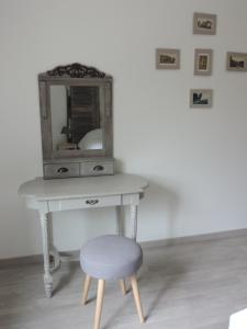 a table with a chair next to a mirror at La Maison d’Elise in Beine