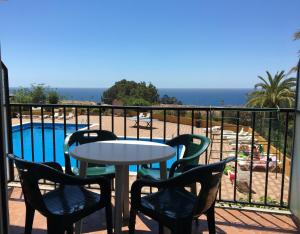 a balcony with a table and chairs and a pool at STUDIOS FACE À LA MER - Cala Llevado in Tossa de Mar