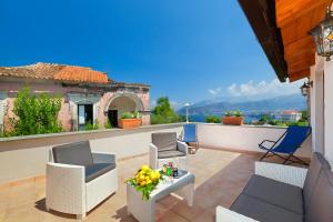 a patio with chairs and a table on a balcony at Gaiano Apt in Sorrento