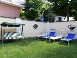 a group of chairs and an umbrella in a yard at Villa Anita - appartamento green in Pescara