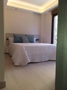 a bedroom with a large white bed with blue pillows at Apartamentos Vacacionales Joctis, 2º B in Fuengirola