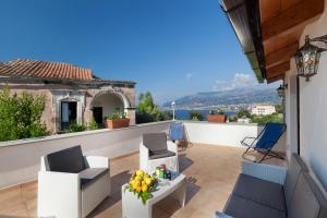 patio z krzesłami i stołem na balkonie w obiekcie Gaiano Apt w Sorrento