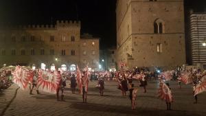un grupo de personas sosteniendo banderas frente a un edificio en Il Sogno di Annalisa Suite en Volterra