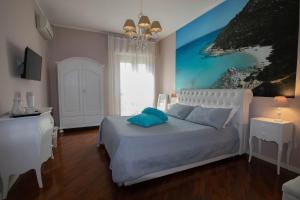 um quarto com uma cama com um quadro na parede em La Casa di Adele Cagliari em Cagliari