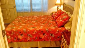a bedroom with a bed with a red blanket and pillows at Keeler Island Princess 508 in Fort Walton Beach +26 photos