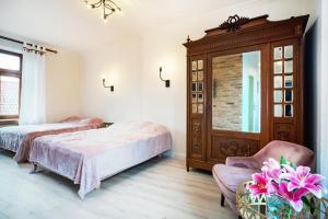 a bedroom with two beds and a chair at Apartamenty Magia in Lublin