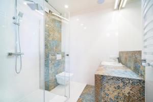 ein Bad mit einer Dusche und einem Waschbecken in der Unterkunft Apartamenty Magia in Lublin