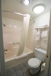 La salle de bains est pourvue de toilettes, d'une baignoire et d'un lavabo. dans l'établissement National 9 Inn, à Buttonwillow