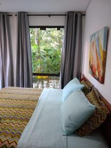 En eller flere senge i et værelse på Suítes Km18praia