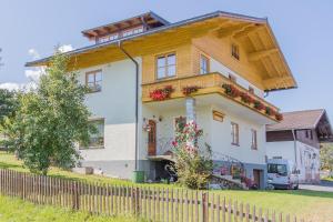 a large white house with flowers on the balcony at Haus Schwab in Lend