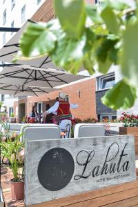 a sign that reads la latina sitting under an umbrella at Hotel Lahuta in Kolgecaj