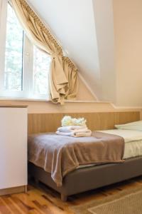 a bedroom with a bed with a window and towels at Pomorze Health&Family Resort -Domki całoroczne in Ustka
