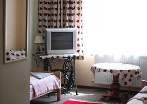 a living room with a tv and a table with a window at Gościniec pod Kłosem in Kłos