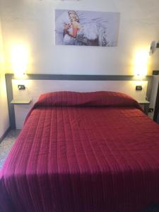 a bedroom with a large bed with a red bedspread at La Casa di Anna in Delebio