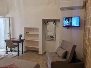a living room with a couch and a tv on a wall at B & B San Giovanni 9 in Gallipoli