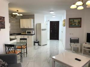 eine Küche und ein Wohnzimmer mit einem Kühlschrank und einem Tisch in der Unterkunft Regency Towers Apartments in Hurghada