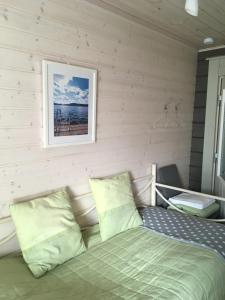 a bedroom with a bed and a picture on the wall at Rantakatti Apartments in Punkaharju