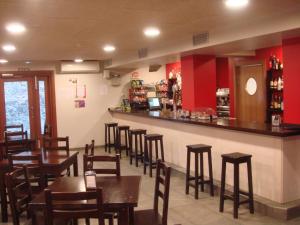un restaurante con mesas de madera y un bar en Hostal Betelu, en Betelu