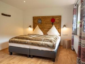 Schlafzimmer mit einem großen Bett mit einem Kopfteil aus Holz in der Unterkunft Black Forest Apartements by Hotel Grüner Baum Feldberg in Feldberg