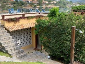 una casa en una colina con sillas en el techo en Praia da Ferradurinha Guest House en Búzios