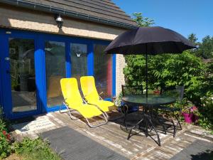 stół, 2 krzesła i parasol na tarasie w obiekcie Jardins Naturels w mieście Biesme