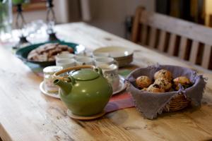 uma mesa com um bule de chá e um cesto de comida em The Guest House em Vallorcine