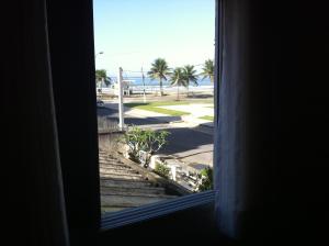 ein Fenster mit Blick auf den Strand von Aominiumominium in der Unterkunft Edifício Galassi in Praia Grande