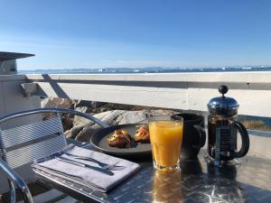 a table with a plate of food and a glass of orange juice at Hotel Icefiord in Ilulissat