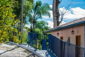 a blue gate in front of a house with trees at Pousada Vila Rica in Cunha