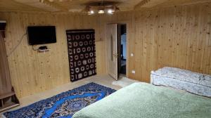 een slaapkamer met een bed en een tv in een kamer bij Садиба "Ековид" in Krivorovnya