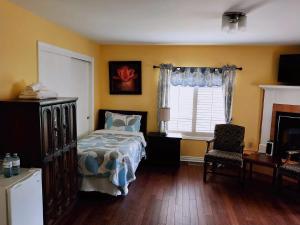 1 dormitorio con cama, escritorio y ventana en Butterfly Manor en Cataratas del Niágara
