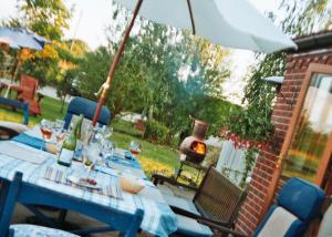 a table with a blue tablecloth and an umbrella at The Paddock at Peacock Farm near Belvoir Castle in Redmile +6 photos