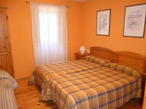 1 dormitorio con 1 cama con manta a cuadros en Hostal Betelu, en Betelu