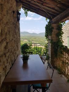 a wooden table in a stone building with a view at maison de charme en Luberon in Grambois