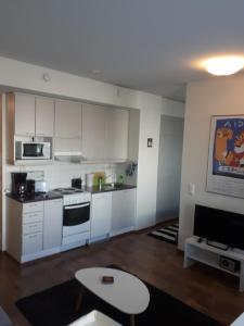 een keuken met witte kasten en een fornuis met oven bij Kaira Apartments in Rovaniemi