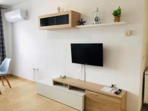 sala de estar con TV de pantalla plana en la pared en Apartamento Arosa Playa en Calpe