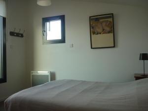 - une chambre avec un lit blanc et une fenêtre dans l'établissement La Maison De La Rade, à Le Relecq-Kerhuon
