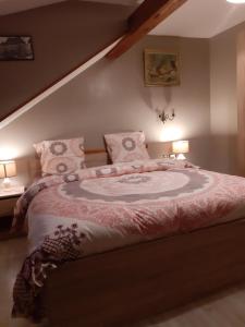 een slaapkamer met een groot bed met 2 lampen bij La tour Gîtes du Florimont in Ingersheim