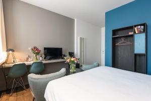 a bedroom with a bed and two chairs and a desk at Zakske13 - Design Boutique B&B in Bruges city centre in Bruges