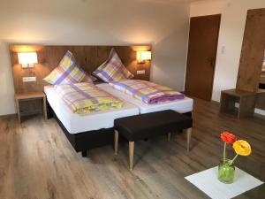 1 Schlafzimmer mit 2 Betten, einem Tisch und Blumen in der Unterkunft Gasthof Rössle Ochsenwang in Bissingen an der Teck